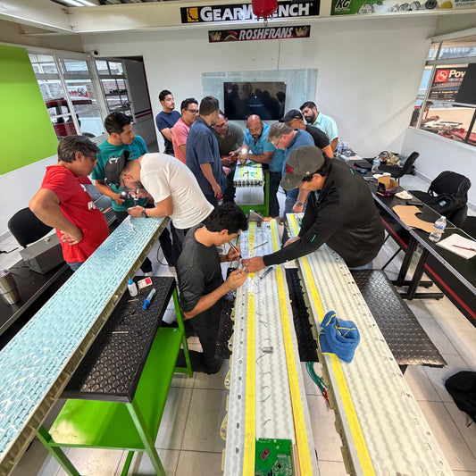 Curso práctico de vehículos eléctricos con alumnos trabajando en módulos de batería EV, diagnóstico SOC SOH y procedimientos de seguridad en alto voltaje