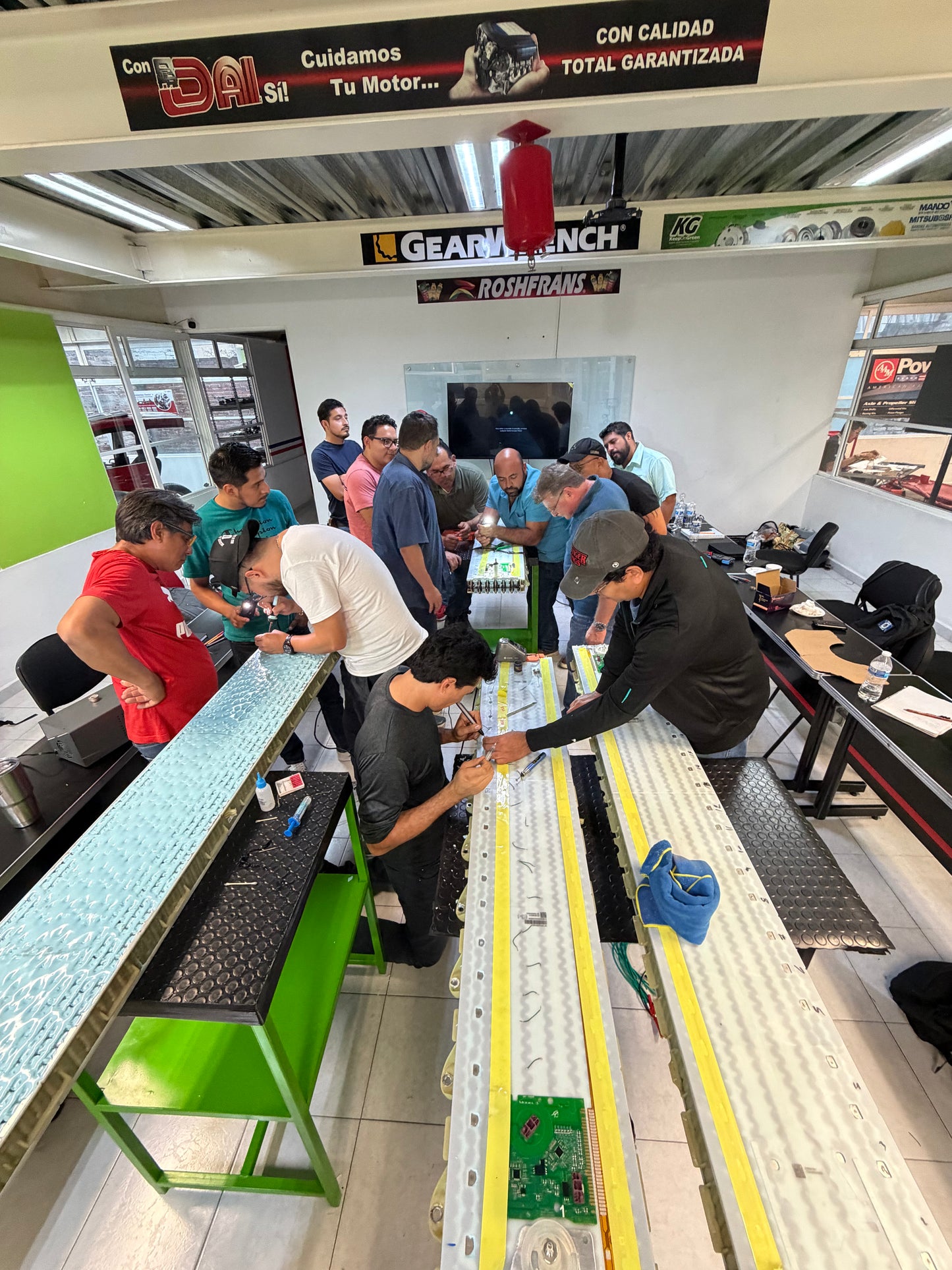 Curso práctico de vehículos eléctricos con alumnos trabajando en módulos de batería EV, diagnóstico SOC SOH y procedimientos de seguridad en alto voltaje