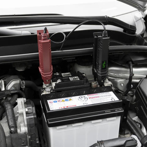 Thinkcar Thinkeasy V2 en uso sobre batería automotriz de 12V. Verificación de voltaje y diagnóstico seguro sin chispas ni sobrecalentamiento.