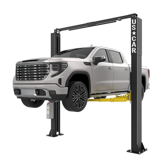 Elevador automotriz US-CAR US-10AC de 2 postes 10,000 lb levantando pickup, brazos asimétricos con travesaño superior para talleres mecánicos.